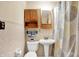 Well-lit bathroom featuring a pedestal sink, built-in shelving and a shower curtain at 2110 Fisher Ave, Speedway, IN 46224