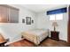 Bright bedroom featuring hardwood floors, side table, and a patterned quilt at 2110 Fisher Ave, Speedway, IN 46224
