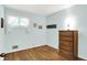 Bedroom with hardwood floors, wooden dresser, and a bright window at 2110 Fisher Ave, Speedway, IN 46224