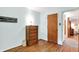 Bedroom with hardwood floors, wooden dresser, and a bright window at 2110 Fisher Ave, Speedway, IN 46224