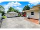 View of a house with a concrete driveway and a two-car detached garage, on a sunny day with blue skies and puffy white clouds at 2110 Fisher Ave, Speedway, IN 46224
