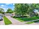 Charming exterior view with manicured lawn, mature trees, and detached garage, offering curb appeal and a welcoming atmosphere at 2110 Fisher Ave, Speedway, IN 46224