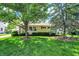 Charming single-story home with a lush green lawn and mature trees, offering great curb appeal at 2110 Fisher Ave, Speedway, IN 46224