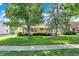 Well-maintained home with a lush green lawn, mature trees, and manicured landscaping, enhancing its curb appeal at 2110 Fisher Ave, Speedway, IN 46224