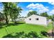 View of a well-maintained garage and fenced yard with a lush green lawn, on a sunny day with blue skies and puffy clouds at 2110 Fisher Ave, Speedway, IN 46224