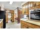 Galley kitchen with built-in appliances, wooden cabinetry, and tile flooring at 2110 Fisher Ave, Speedway, IN 46224