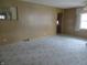 Living room featuring carpet, paneled walls, and a view into the kitchen at 2110 Fisher Ave, Speedway, IN 46224