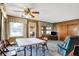 The living room is decorated with a ceiling fan, many windows, and carpeted floors at 2110 Fisher Ave, Speedway, IN 46224