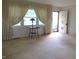 Bright living room with large window, neutral carpet, and an open entry door, enhancing the home's inviting atmosphere at 2110 Fisher Ave, Speedway, IN 46224