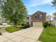 Charming two-story home featuring a brick facade, attached garage, and a well-maintained front yard at 2116 Orchid Bloom Dr, Indianapolis, IN 46231