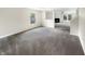 Bright, neutral living room featuring neutral paint and carpet with view to kitchen and fireplace at 2116 Orchid Bloom Dr, Indianapolis, IN 46231