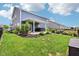Landscaped backyard featuring a covered patio, hot tub, firepit, and manicured lawn at 220 Sawdust Trl, Greenfield, IN 46140