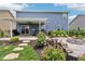Backyard with covered patio, hot tub, firepit, lush landscaping, and fenced yard at 220 Sawdust Trl, Greenfield, IN 46140
