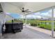 Covered patio with a hot tub, ceiling fan, and fenced backyard with a water view at 220 Sawdust Trl, Greenfield, IN 46140