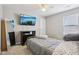 Simple bedroom with bed, grey linens, and wall mounted television at 220 Sawdust Trl, Greenfield, IN 46140