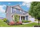 Two-story home with blue siding, a well-manicured lawn, and colorful flowers, showcasing a welcoming curb appeal at 220 Sawdust Trl, Greenfield, IN 46140