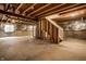 Unfinished basement with concrete floor, exposed ceiling, and stairway at 2209 S Logan Dr, New Palestine, IN 46163