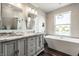 Bright bathroom with double vanity, soaking tub, and a large window overlooking the yard at 2209 S Logan Dr, New Palestine, IN 46163