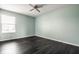 Bright bedroom with soft blue walls, a window, and dark hardwood floors at 2209 S Logan Dr, New Palestine, IN 46163