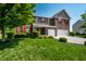 Beautiful two-story home with brick and siding, red shutters, a well-manicured lawn and a two car garage at 2209 S Logan Dr, New Palestine, IN 46163