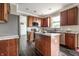 Kitchen with an island, stainless steel appliances, granite countertops, and dark wood cabinetry at 2209 S Logan Dr, New Palestine, IN 46163