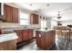 Open kitchen with wood cabinets, granite counters, stainless appliances, breakfast area, and wood floors at 2209 S Logan Dr, New Palestine, IN 46163