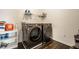 Modern laundry room featuring front-load washer and dryer with shelving above for storage at 2209 S Logan Dr, New Palestine, IN 46163
