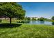 Scenic view of a pond surrounded by lush green grass and mature trees at 2209 S Logan Dr, New Palestine, IN 46163