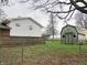 View of the home's backyard featuring a shed and wood fence surrounding the property, with trees in the background at 2414 Constellation Dr, Indianapolis, IN 46229
