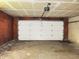 Unfinished garage with exposed ceiling beams and a white garage door, offering ample storage or parking space at 2414 Constellation Dr, Indianapolis, IN 46229