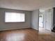 Spacious living room with hardwood floors, neutral paint, a large window, and white trim at 2414 Constellation Dr, Indianapolis, IN 46229