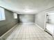 Spacious basement with tile floors, block walls, and natural light from the window at 2419 Tamarack Pl, Anderson, IN 46011