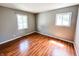 Bright bedroom featuring hardwood floors, two windows, and neutral gray walls at 2419 Tamarack Pl, Anderson, IN 46011