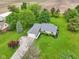 Aerial view displays the home's layout, lush landscaping, and gravel driveway at 3020 E 400 S, Lebanon, IN 46052