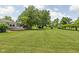 Sprawling green backyard featuring a wooden deck, mature shade trees, and lush lawn at 3020 E 400 S, Lebanon, IN 46052