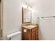 A modest bathroom with a wooden vanity topped with a stone countertop and a well-lit mirror at 3020 E 400 S, Lebanon, IN 46052