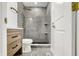 Updated bathroom features granite-look tiled shower and floor plus a wood vanity at 3237 Thurston Dr, Indianapolis, IN 46224