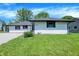 A nice looking single-story home with white siding and a green lawn, with nice landscaping at 3237 Thurston Dr, Indianapolis, IN 46224