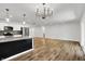 Open-concept living room with modern light fixture, kitchen island and stainless steel appliances at 3237 Thurston Dr, Indianapolis, IN 46224