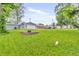 Spacious backyard featuring a well-maintained lawn, a stone fire pit, and a detached garage at 353 S Indiana St, Danville, IN 46122