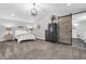 Comfortable bedroom featuring a carpeted floor, ample closet space via sliding barn door, and modern decor at 353 S Indiana St, Danville, IN 46122