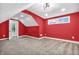 Bedroom with red walls, carpet, two windows with natural light, and modern lighting fixture at 353 S Indiana St, Danville, IN 46122