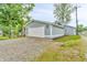 Detached garage with a white garage door, blue siding, and a gravel driveway for ample parking at 353 S Indiana St, Danville, IN 46122