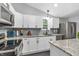 Bright kitchen showcases white cabinets, granite countertops, stainless steel appliances, and modern gray backsplash at 353 S Indiana St, Danville, IN 46122