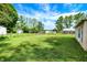 Expansive backyard on a sunny day, surrounded by mature trees and partial fencing at 356 Daugherty St, Columbus, IN 47201