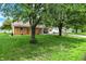 View of a well-kept ranch-style home with mature landscaping and a swing hanging from a tree in the front yard at 356 Daugherty St, Columbus, IN 47201