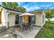 Back patio with dining set and umbrella adjacent to a well manicured lawn at 356 Daugherty St, Columbus, IN 47201