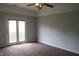 Spacious carpeted bedroom with ceiling fan and access to outdoor space at 3908 Roundwood Dr, Indianapolis, IN 46235