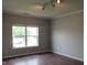 Bedroom featuring hardwood floors and a large window at 3908 Roundwood Dr, Indianapolis, IN 46235