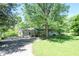 Scenic shot of a home featuring mature trees, detached garage, and a driveway, blending nature and convenience at 4023 Cedar Hills South Dr, Greenwood, IN 46143